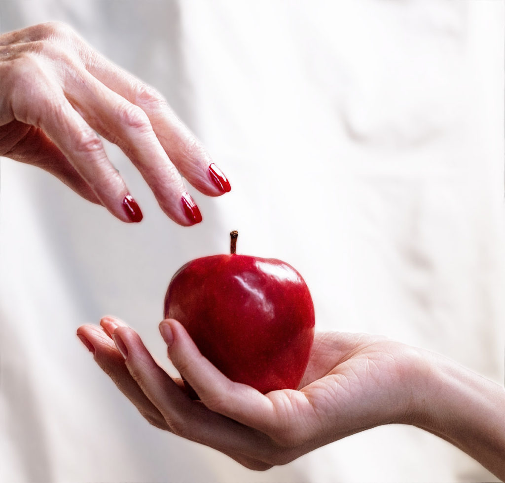 old hand reaching for apple in young hand